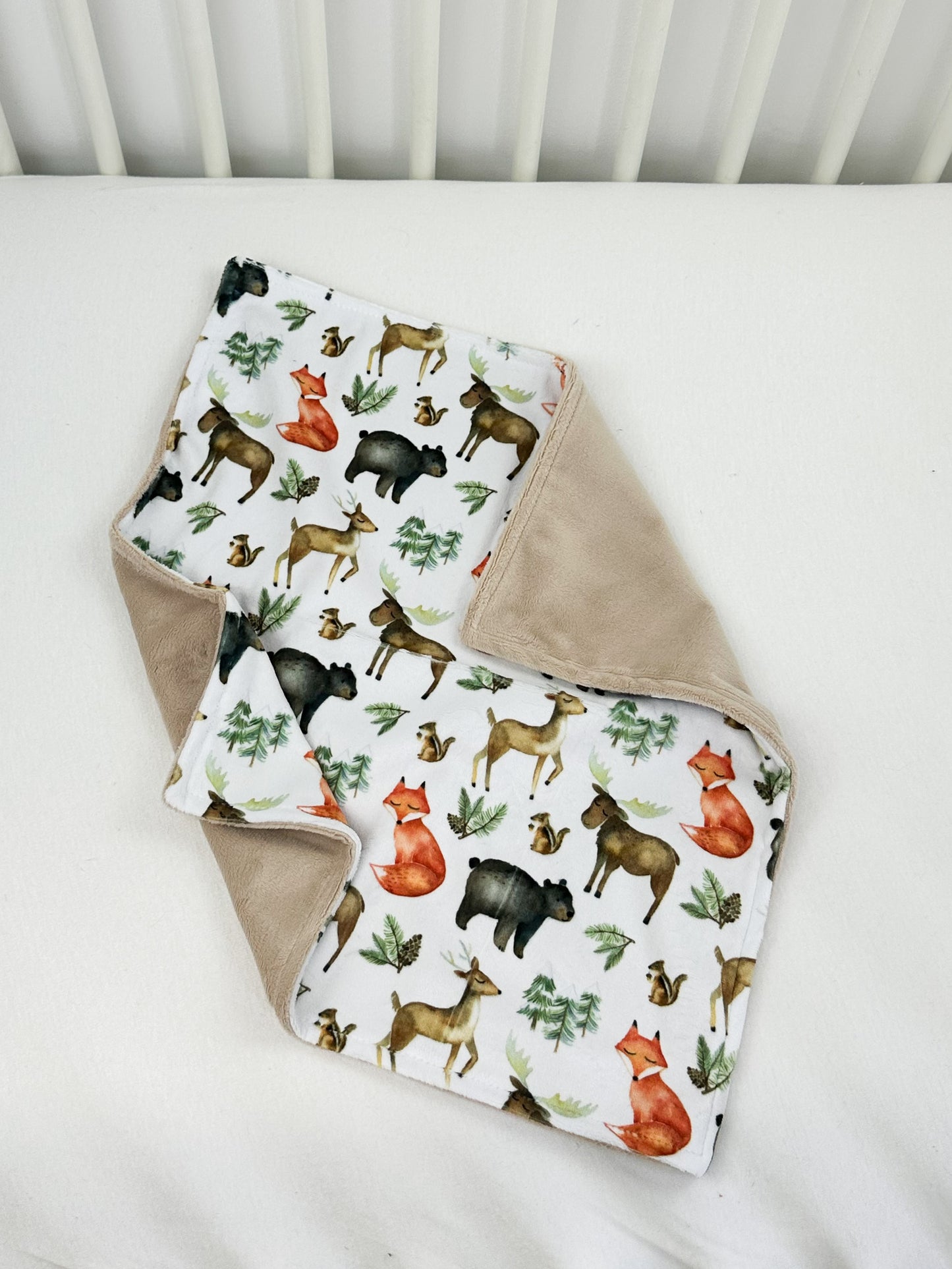 a baby blanket with a deer pattern on it