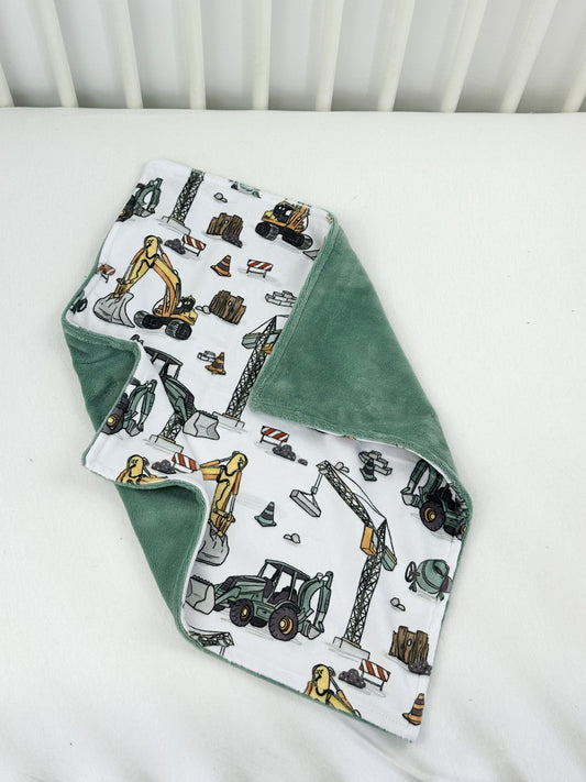 a baby bib with construction vehicles on it