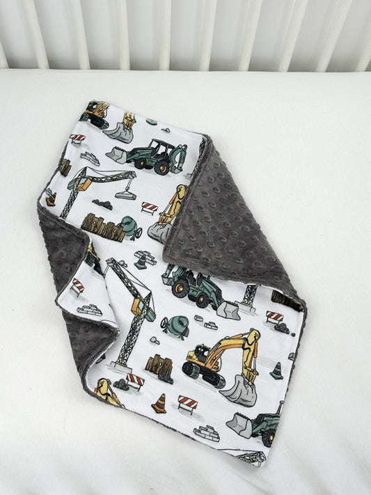 a baby blanket with construction vehicles on it