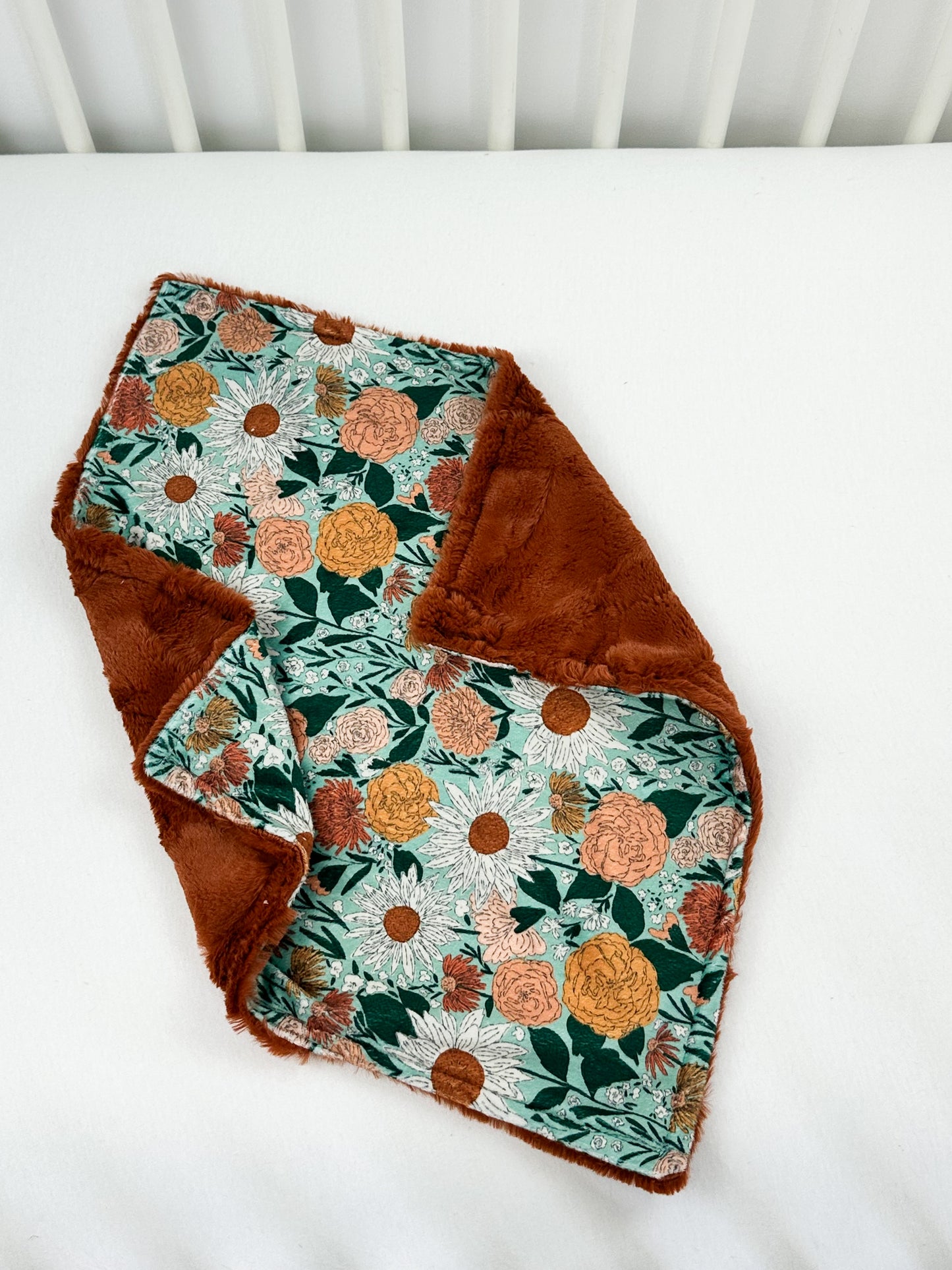 a baby blanket with a flower design on it