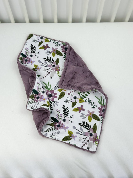 a white crib with a purple blanket and a white crib with a purple