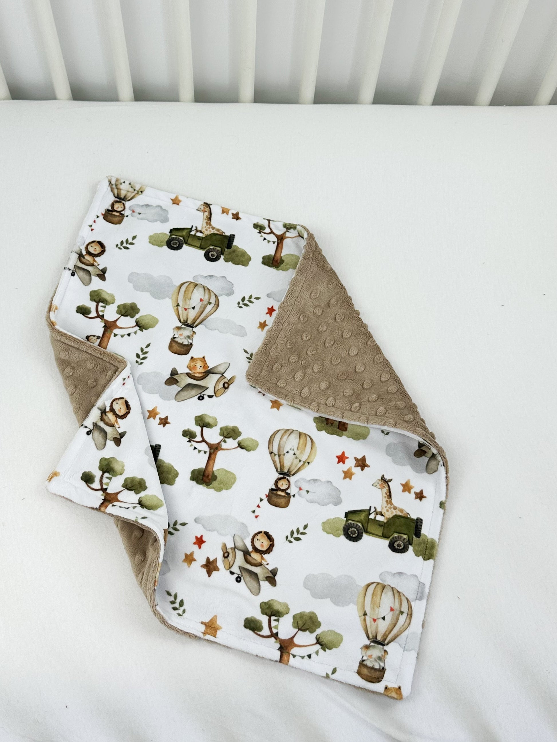 a baby bib and burp cloth on a bed