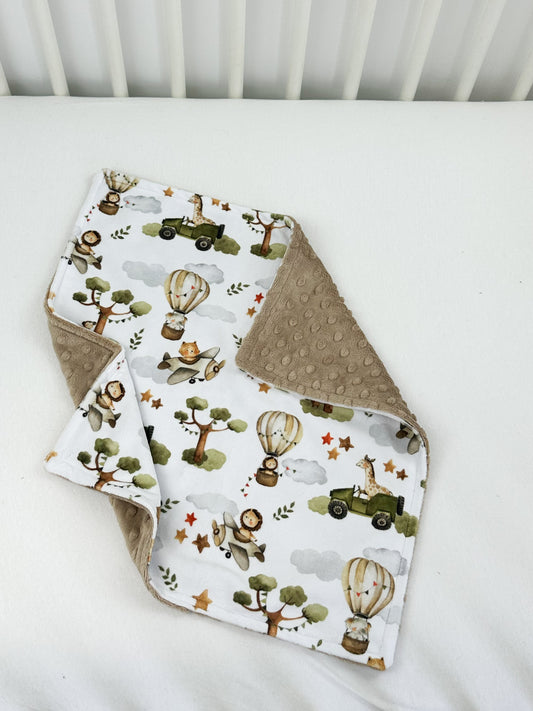 a baby bib and burp cloth on a bed