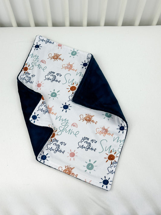 a baby blanket laying on top of a white crib