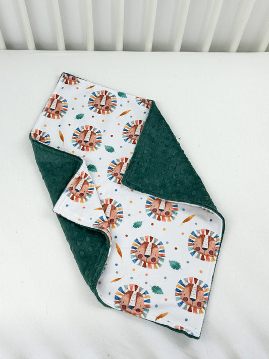 a white crib bed with a green and white blanket