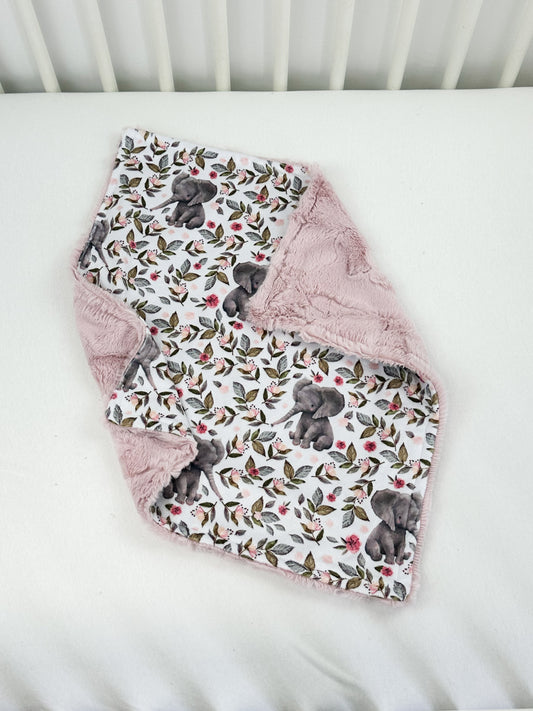 a white crib with a pink blanket on top of it