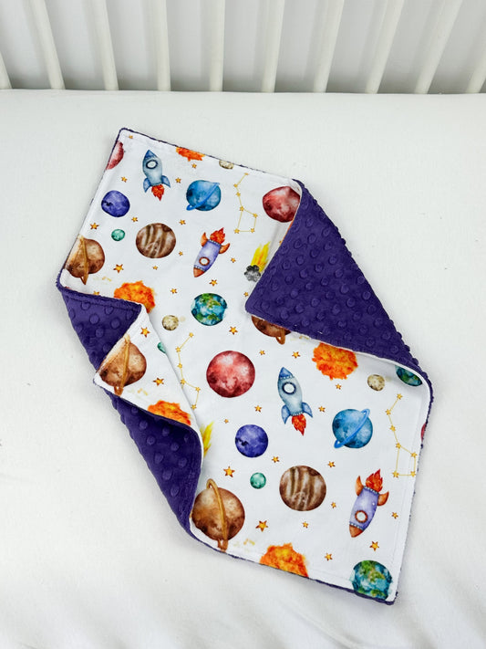 a baby bib with a space theme on it