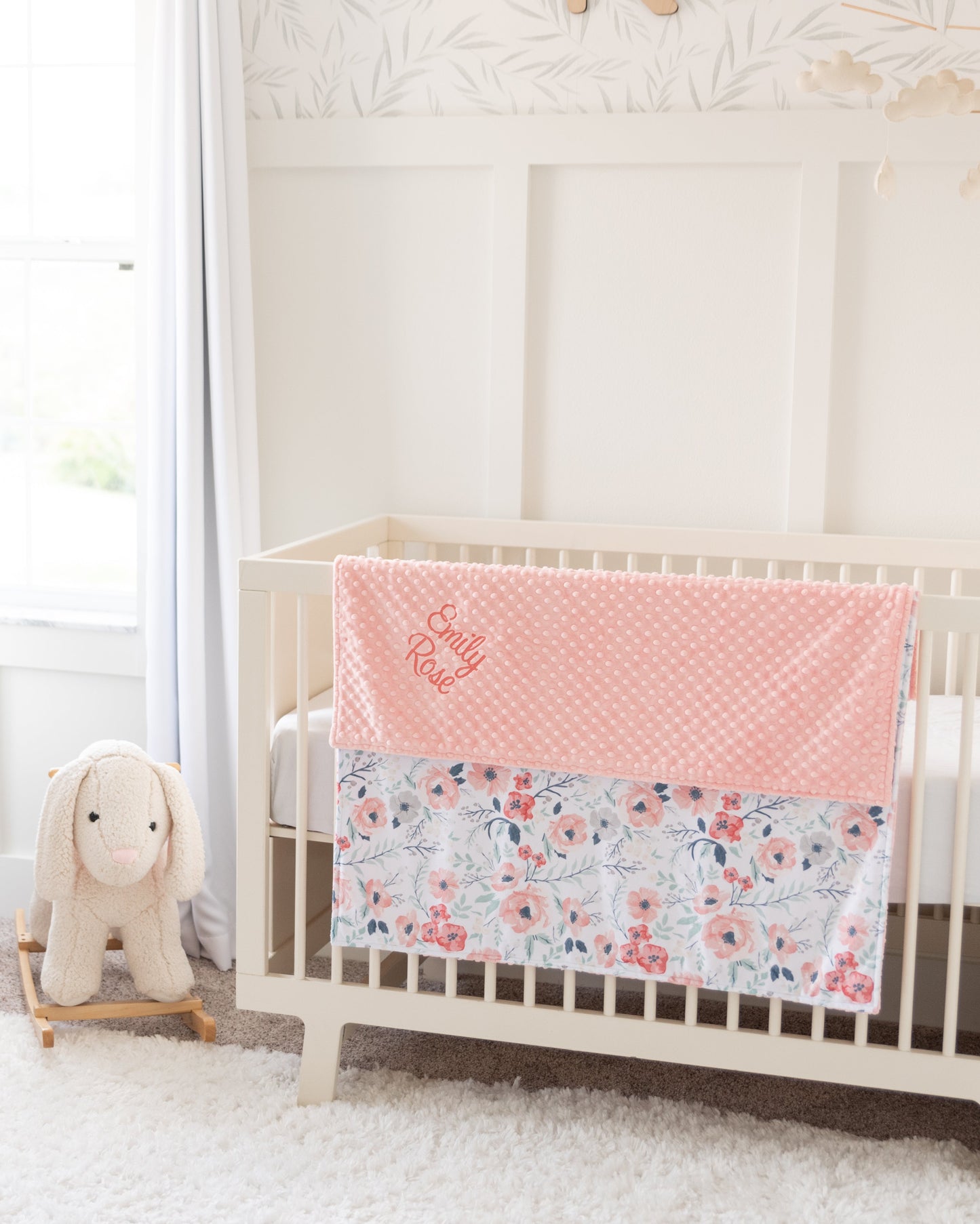 Nursery room with a crib, chair, and rocking horse in a bright room.