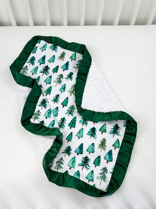 a baby's crib with a green and white blanket on top of it