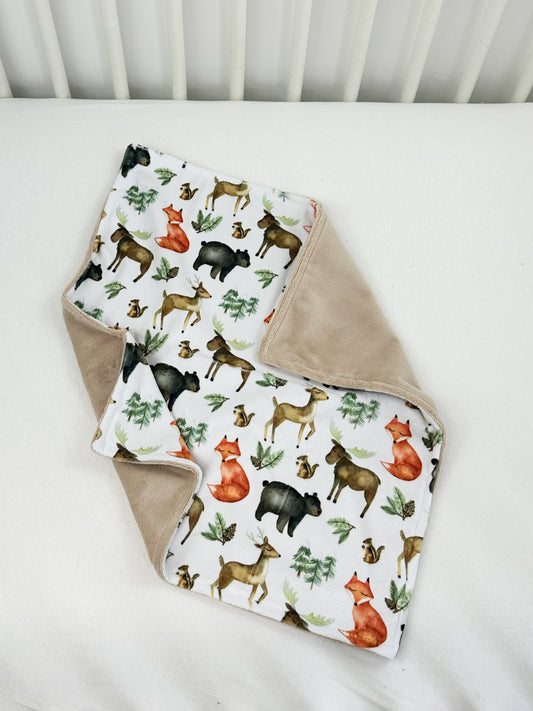 a baby blanket with a deer pattern on it
