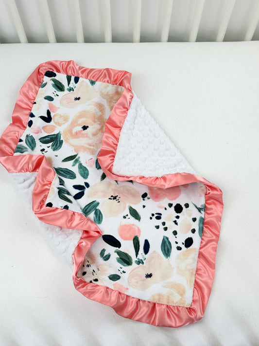 two baby bibs laying on top of a white crib